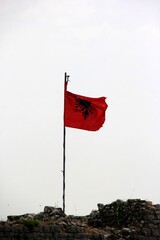 Shkoder, Albania - june 24, 2023: Albania national flag waving on the tower of the old Shkodra fortress, Rozafa Castle
