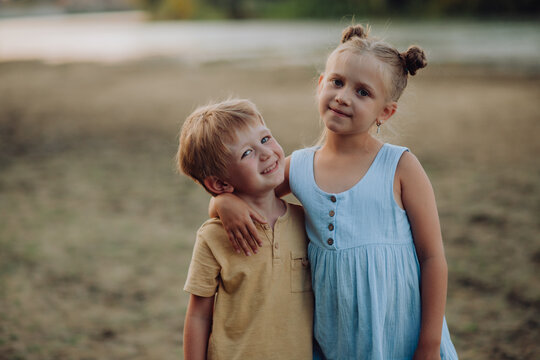 cute children are walking in the park in nature. A little boy and a beautiful girl hug, happy brother and sister. family relationships, love. summer holidays, children's leisure and entertainment