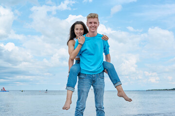 Happy cheerful teenage friends having fun together on beach.