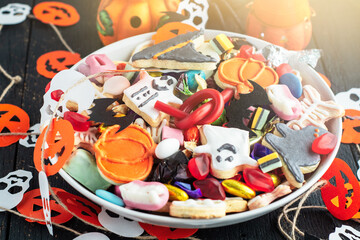 decorated holiday table Halloween Jack o Lantern candy bowl with candy and halloween cookies Trick or Treat dark background