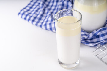Non-Homogenized, whole milk, cream-top layered dairy product, Creamline Milk concept. Organic farm natural, unpasteurized milk in glass and jug, on white kitchen table copy space