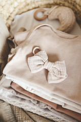Stack of neutral bodysuits for a newborn in a cradle