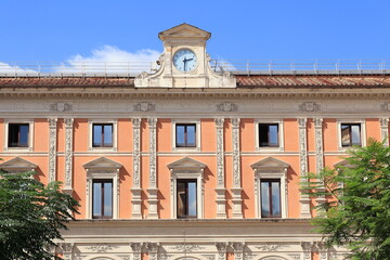 Fototapeta na wymiar Piazza San Silvestro Square Pink Building Facade with Clock in Rome, Italy