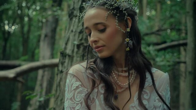 Attractive Dryad Or Forest Fairy found a treasure chest of jewelry and opens it. Charming girl in a transparent white dress in the forest. Mavka Naiad Forest Nymph In A Fairy Tale