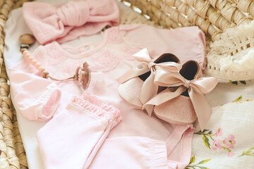 Fototapeta na wymiar Lovely pink slippers and bodysuit for a newborn girl