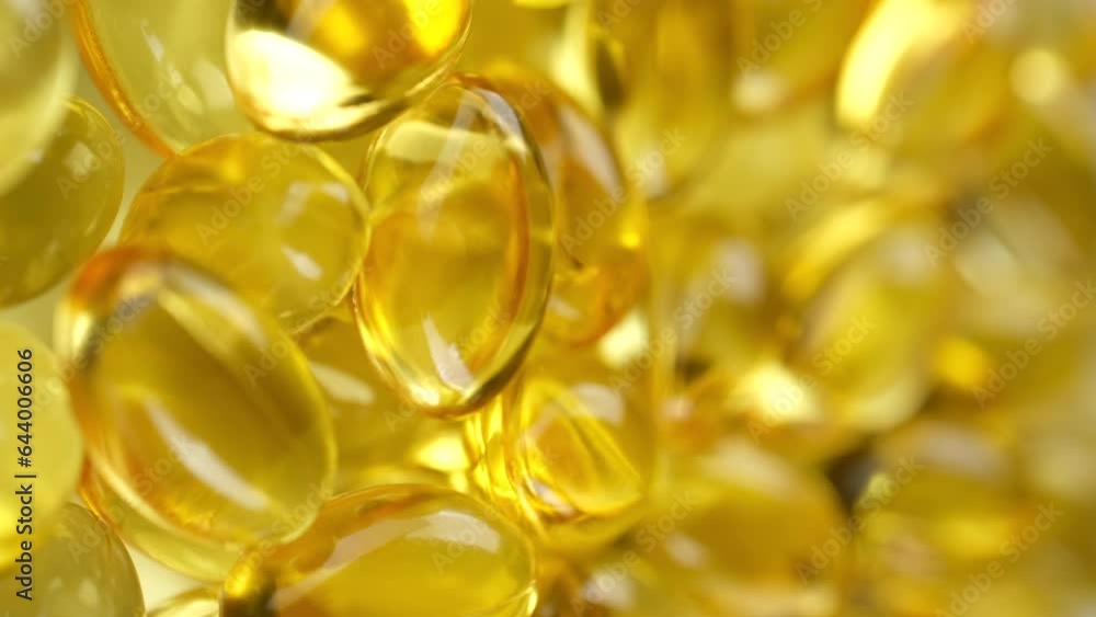 Wall mural yellow softgel capsule vitamins omega 3 or fish oil rotate. pharmaceutical industry. vertical video