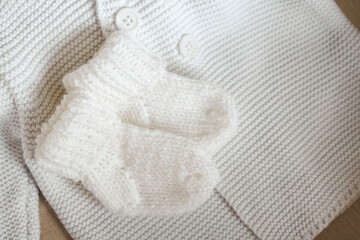 Fototapeta na wymiar Knitted children's socks and handmade sweater