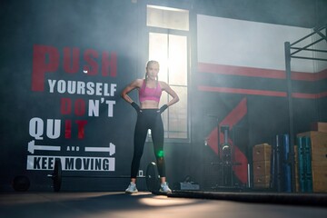 Muscular Asian woman conquers battle ropes, showcasing her impressive physical prowess in an intense workout in a training gym with unwavering determination