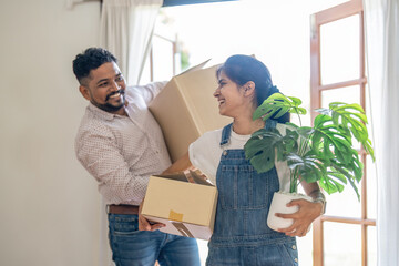 Couple indian happy carrying box on moving day in of home new