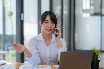 Asian businesswoman modern professional talking with client on the phone with a confident demeanor and effective communication skill. business, marketing, sale and communication project.
