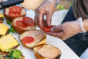 Cooking delicious Burgers. cooking meat burgers with bacon, cheese and vegetables, selective focus. bright plan.