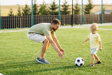 Father with son playing football at the football field