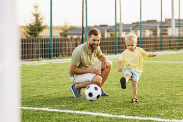 Father with son playing football at the football field