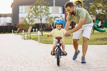 Father teaching his little son to ride a bicycle