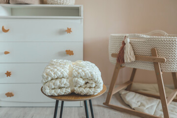 Handmade knitted blanket for a newborn in a nursery