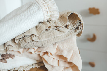 Stack of baby muslin blankets and newborn diapers