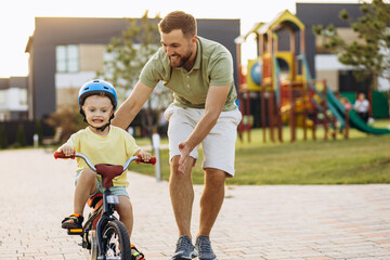 Father teaching his little son to ride a bicycle