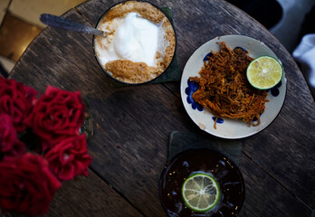Top view of Vietnamese snack dried beef jerky and coconut coffee on wood table