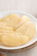 Fresh pomelo fruit on wooden table background.