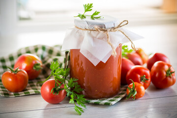 Cooked homemade tomato juice canned in a jar of natural tomatoes.