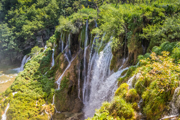 Fototapeta na wymiar Top view of the beautiful picturesque waterfalls on Plitvice Lakes. Rocks and green trees around lakes with blue water. Breathtaking view in the Plitvice Lakes National Park .Croatia