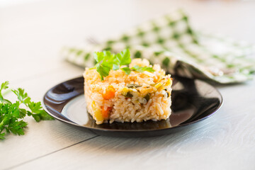 Cooked boiled rice with zucchini, carrots and vegetables in a plate