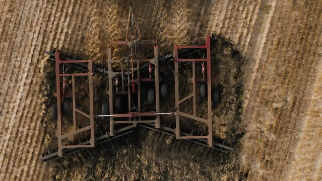 Disking the field. Tractor cultivating land of Disc Harrow. Tractor at a disking of ground Close up. Agriculture. Aerial view of tractor plowing the field. Slow motion video