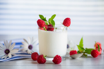 Sweet cooked homemade yogurt with fresh raspberries in a glass.