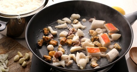 Cooking seafood dishes. Seafood cocktail with shrimp, octopus and mussels are fried in a pan. A series of photos to visualize the recipe. Mediterranean or Asian cuisine. Food preparation.