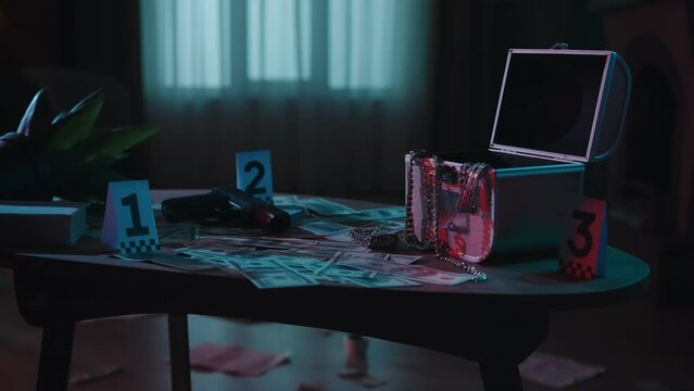 Closeup shot of the table with evidence numbers and objects in the dark apartment room. Crime scene creative concept.