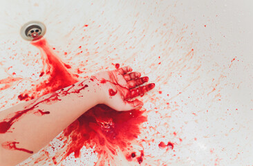 Bloody hand of depressed woman in shower.