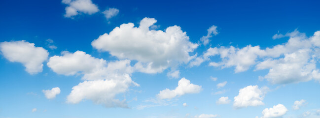 Naklejka na ściany i meble The sky with clouds as a backdrop. Sky in the daytime. Panorama in large resolution. White clouds and blue sky. Photo for design and wallpaper.