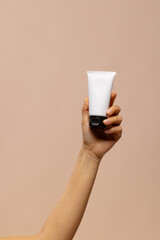 Hand of asian woman holding tube of beauty cream with copy space