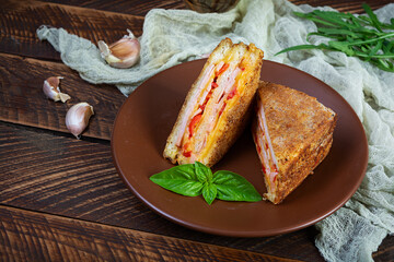 Sandwiches fried in breadcrumbs with ham, cheese and tomatoes