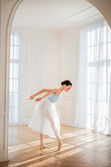 A young ballerina is rehearsing in the studio. happy young ballerina exercising in the barre. Young...