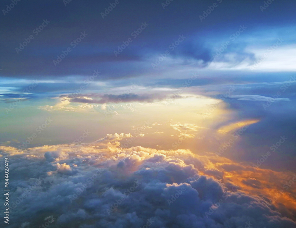 Wall mural stunning arial view of golden sunrays and rays of sunlight over the clouds on the blue sky backgroun