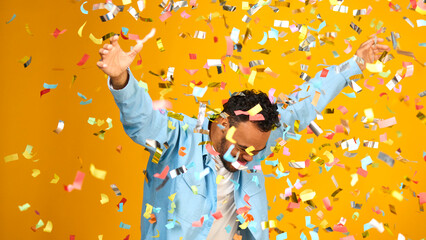 Studio Shot Of Man With Down Syndrome Celebrating Big Win Showered In Tinsel Confetti