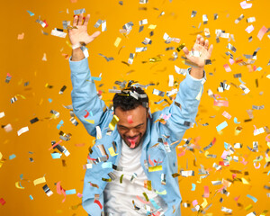 Studio Shot Of Man With Down Syndrome Celebrating Big Win Showered In Tinsel Confetti