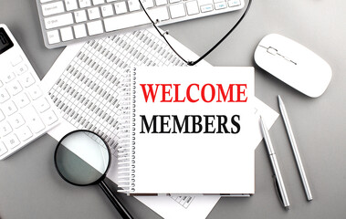 WELCOME MEMBERS text on notepad on chart with keyboard and calculator on grey background