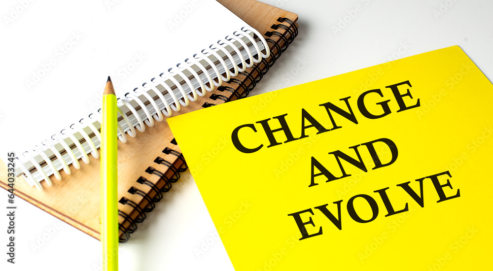Aufkleber change and evolve text written on a yellow paper with notebook