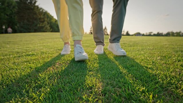 Close up of elderly man and woman walking on green grass