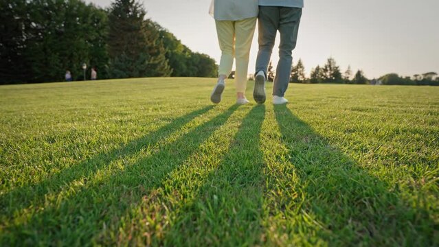 Active couple strolling close to each other through field