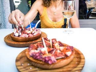 Woman eating Pulpo a la Gallega with potatoes. Galician octopus dishes. Famous dishes from Galicia, Spain - 644036432