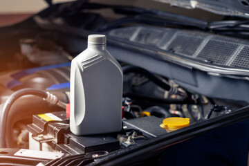 Car lubricant gallon or from gray bottle on engine background Oil change service, auto repair shop Technology and transportation industry