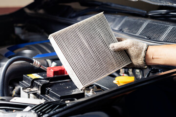Repair and check car air conditioning system Technician holds car air filter to check cleanliness Clogging dirty or replacing the filter. Engine and transportation industry - obrazy, fototapety, plakaty