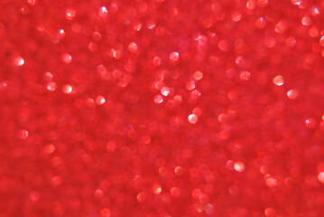 Red de focused sparkle glitter background with particles close up