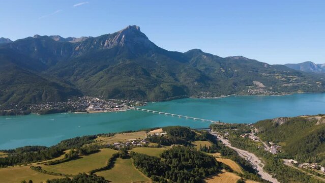 Aerial morning view of Serre-Poncon lake with Savines-le-Lac village and Grand Morgon peak. Durance Valley in summer. Hautes-Alpes (Alps), France