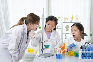 young attractive asian female scientist as a mentor is enjoy teaching the students to chemistry experiments, kids studying science in laboratory class