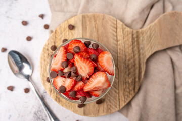 Vanilla yogurt bowl topped with fresh strawberries and sugar free chocolate chips. 