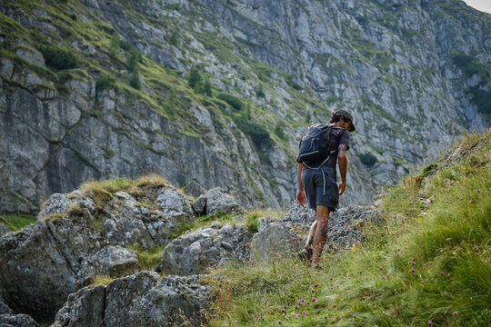 Man traveler with backpack is hiking in mountain.Traveling in nature.Rearview shot of a middle aged man hiking in the mountains. Bucegi Mountains, Romania